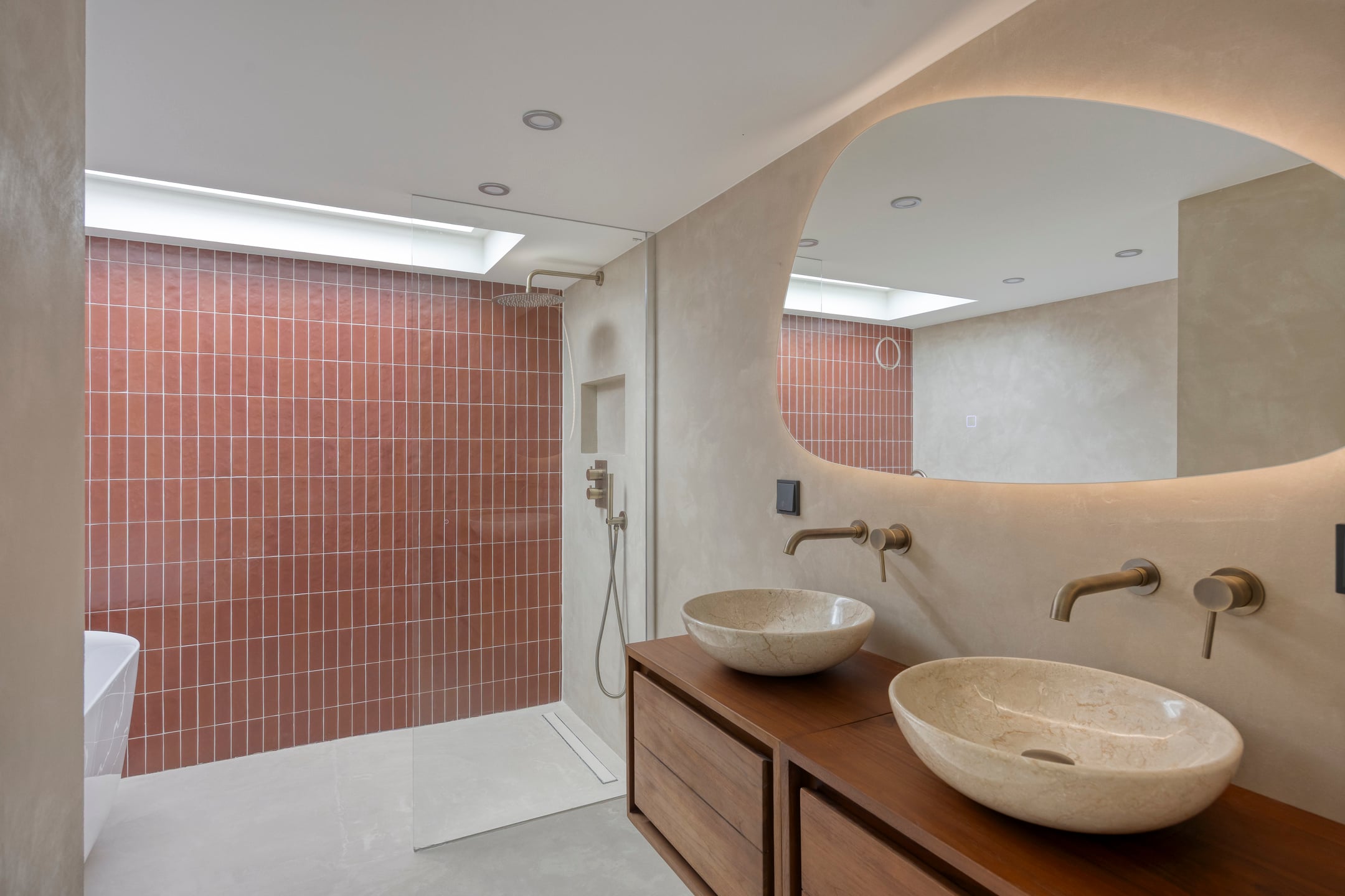 Badkamer met terracotta tegels en dubbele wastafel